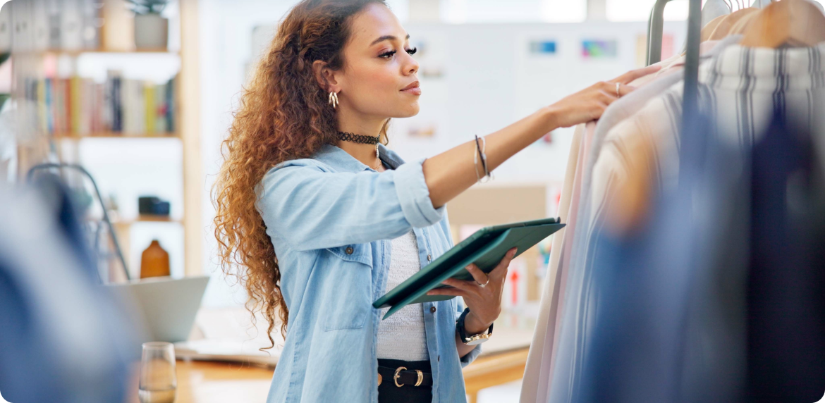 A customer woman examines a clothing item in a retail setting, showcasing her interest and attention to clothing and a retail app