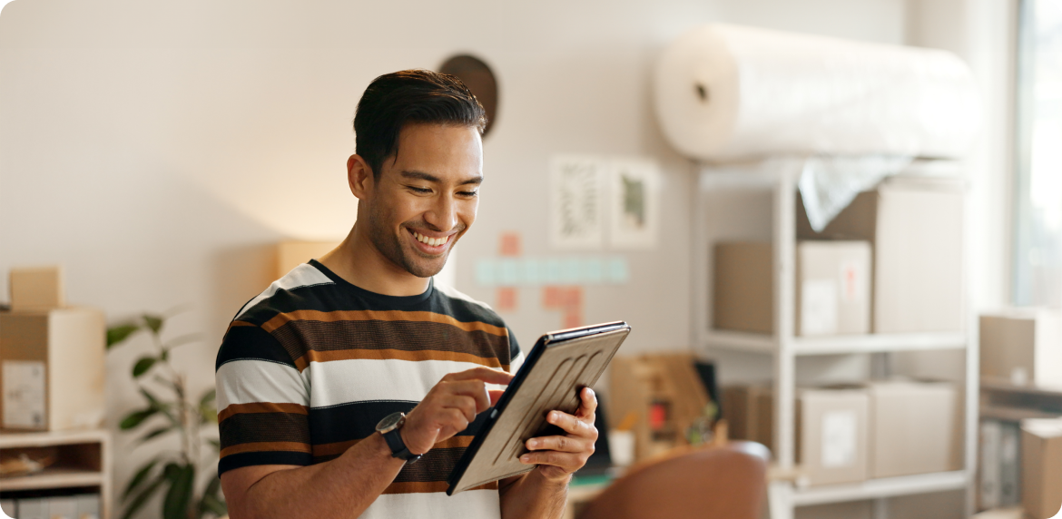 A customer smiles while engaging with a tablet computer, showcasing a moment of enjoyment from his financial services experience.