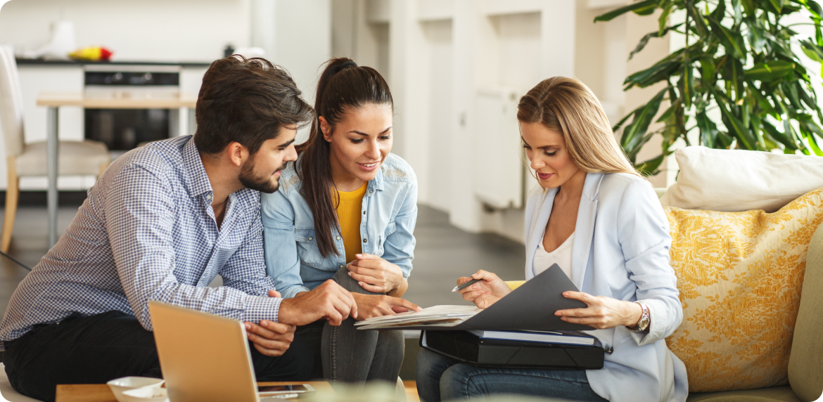 Three real estate agents reviewing a paper database and comparing notes in a home