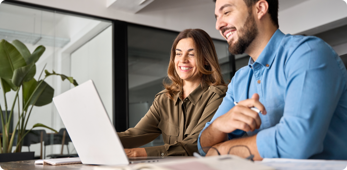 Male and female co workers reviewing retail data in a computer screen in an office setting