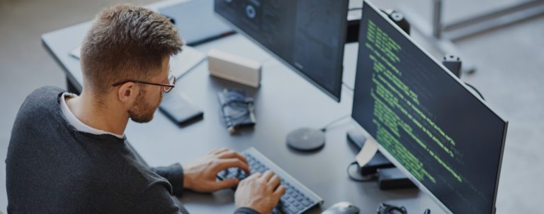 A man types on a computer, focused on the screen in front of him.